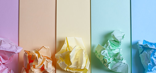 Crumpled colored paper on a blue background, smooth colored sheets