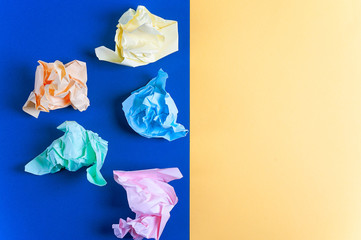 Crumpled colored paper on a blue background