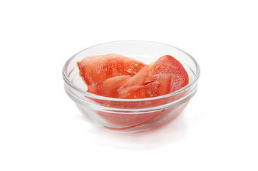 Slices of tomato in glass bowl isolated on white background.