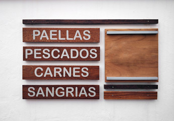 Restaurant menu in spanish on a white wall