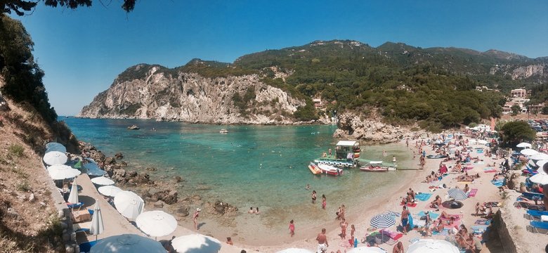 Beautiful summertime panoramic seascape. View of the cliff into the crystal clear azure sea bay and distant islands. Unique secluded beach. Agios Stefanos cape. Afionas. Corfu. Greece.