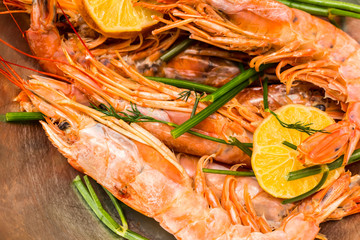 large shrimps group with sprigs of parsley and dill lobes of lemon marinovka before cooking