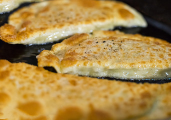 spicy juicy gedza dumplings with meat filling and Chinese cabbage fried in a frying pan golden crust close-up