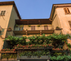 Fototapeta na wymiar country house with a beautiful flowered balcony in the summer season