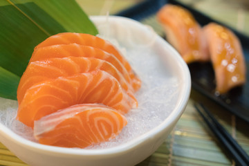 Raw salmon slice or salmon sashimi in Japanese style fresh serve on ice in bowl.