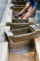 Gemstone panning with a sluice box. Sifting for stones and fossils at the mining sluice. Kids education.