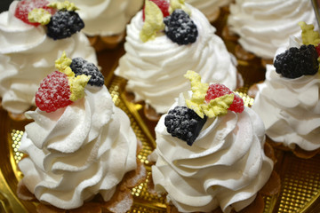 fresh appetizing tartlets with white cream and raspberries and blackberries