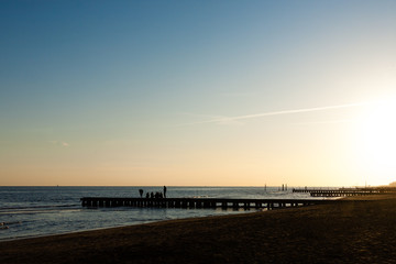Fototapeta na wymiar Beach at dawn, piers perspective view