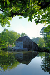 A summertime view from across the pond of the old gristmill at Historic Yates Mill County Park in Raleigh North Carolina
