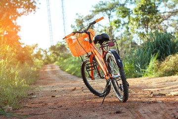 Fototapeta premium Bicycle on the dirt road at sunset