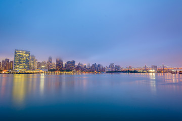 Fototapeta na wymiar Foggy view of the Manhattan skyline from Gantry Plaza State Park, in Long Island City, Queens, New York City.