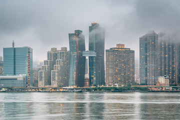 Fototapeta na wymiar Foggy view of the Manhattan skyline from Gantry Plaza State Park, in Long Island City, Queens, New York City.