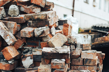 A bunch of old used red bricks on a dump