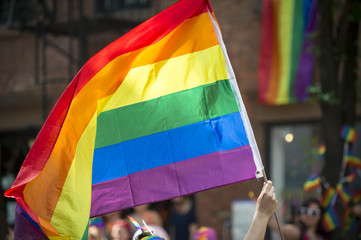 Participant with large backlit rainbow flag in the annual Gay Pride Parade as it passes through Greenwich Village.
