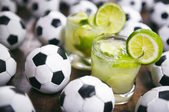 Two fresh lime caipirinhas with soccer footballs Brazilian culture