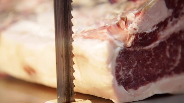 The butcher cuts meat for steaks