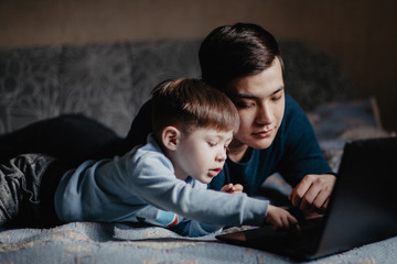 child playing with dad near laptop