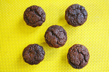 five chocolate cakes on a yellow napkin