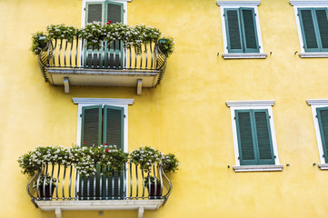 Yellow House with Balconies with Green Flowers in Italy
