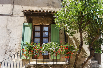 Stone House with Balcony with Blooming Flowers .Cozy Italian  Style Building  Facade 