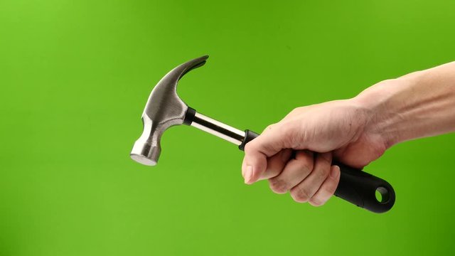 Male hand holding hammer on green background