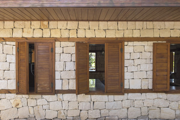 Wooden shutters on the facade of a stone house.