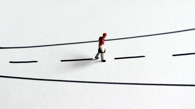 A&nbsp;miniature&nbsp;man&nbsp;walking&nbsp;alone&nbsp;on&nbsp;the&nbsp;street.