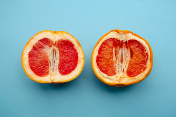 Fresh grapefruit and stale grapefruit on a blue background. Concept of female health. A healthy vagina and an unhealthy vagina.