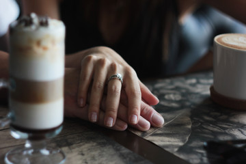 Fototapeta na wymiar Young couple on date in cafe with cappuccino latte, hand in hand