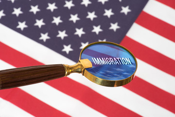 Flagge der USA, eine Lupe und die Zuwanderung nach Amerika