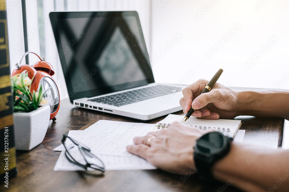 Poster happy casual young asian man working in home or small office with using a laptop and document report