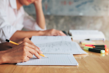 High school or college student group catching up workbook and learning tutoring in classroom and reading, doing homework and lesson practice preparing exam