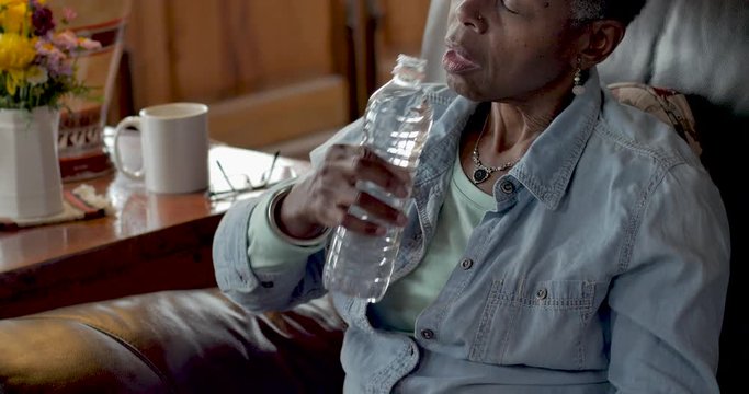 Elderly Senior Woman Drinking Water From A Plastic Bottle