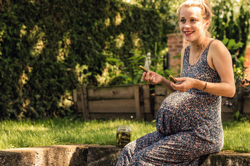confused looking pregnant woman loves to eat pickles in her garden