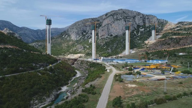 Drone shot of massive infrastructure project, Chinese government owned corporation building bridge and highway in Montenegro, political influence Europe