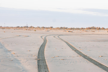 Off road tyre tracks on sand in outskirt of town