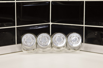 Glass condiment holders in modern kitchen