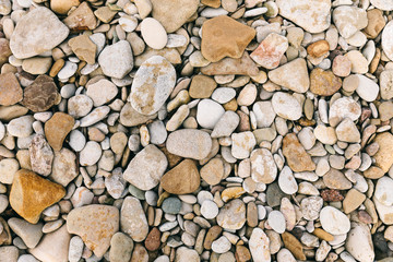 Flatlay view rounded sea pebble stones and multicolor rocks on beach