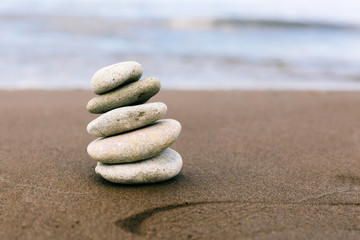 Fototapeta na wymiar Pyramid of stones for meditation on the sea coast. Time management, slow life, simplify