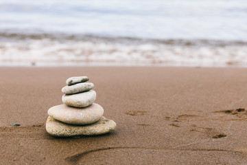 Fototapeta na wymiar Pyramid of stones for meditation on the sea coast. Time management, slow life, simplify