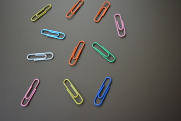 Color clips of different colors are scattered on a brown matte background