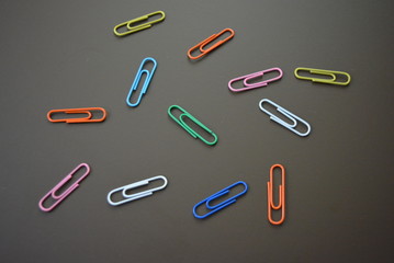 Color clips of different colors are scattered on a brown matte background