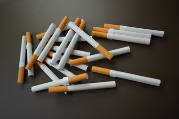 Chaotically decomposed cigarines on a brown matte background