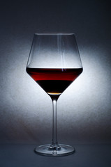 wine glass oglass of red wine on a dark background