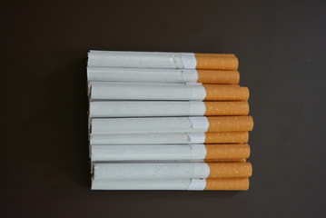 Cigarettes lying in a bunch on a brown matte background