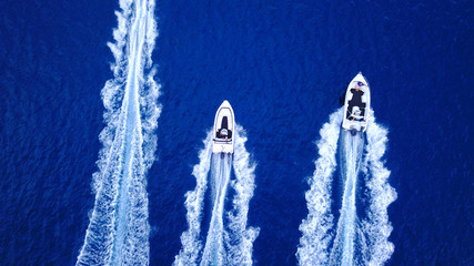 Aerial birds eye view from drone of boats cruising in deep blue sea