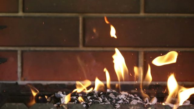 video with bright orange fire with sparks on brick wall background