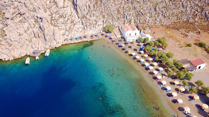 Fototapeta premium Aerial bird's eye view photo taken by drone of famous tropical rocky beach of Agios Nikolaos with clear turquoise waters, Symi island, Dodecanese, Greece