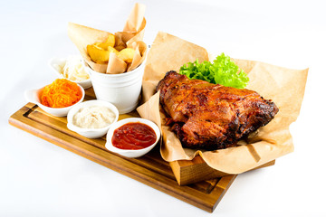 Juicy fried chicken with French fries on the wooden board on lig