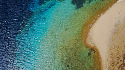 Aerial bird's eye view photo taken by drone of famous rocky beach of Livadi Geranou with turquoise clear waters, Patmos island, Greece